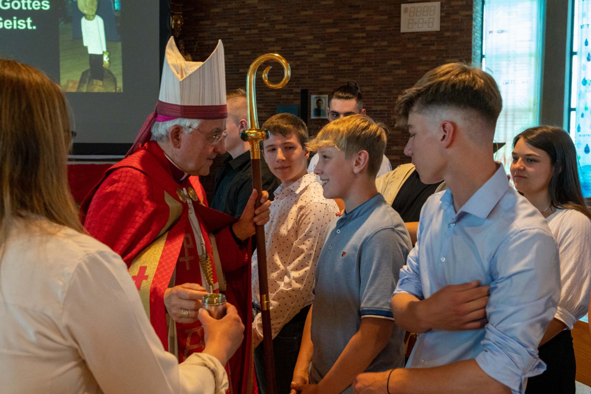 Weihbischof Gebert spendet Jugendlichen in der Jugendkirche MIA das Sakrament der Firmung.