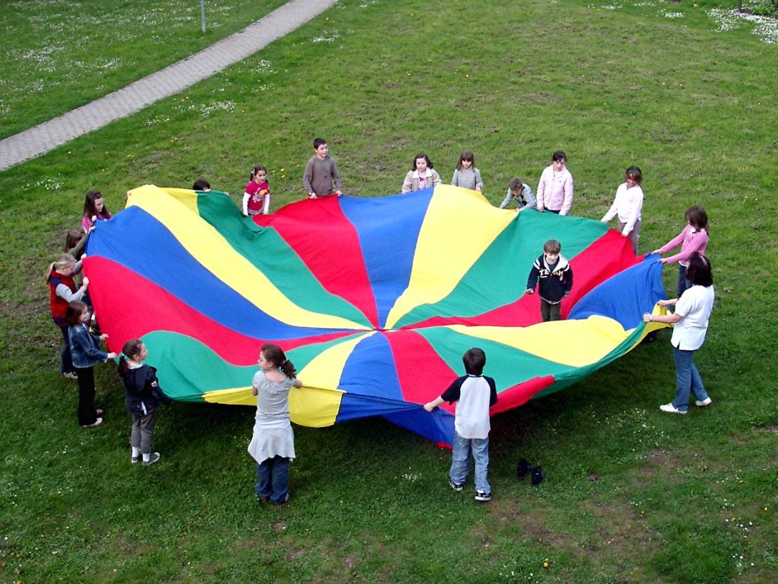 Kinder spielen mit Fallschirm
