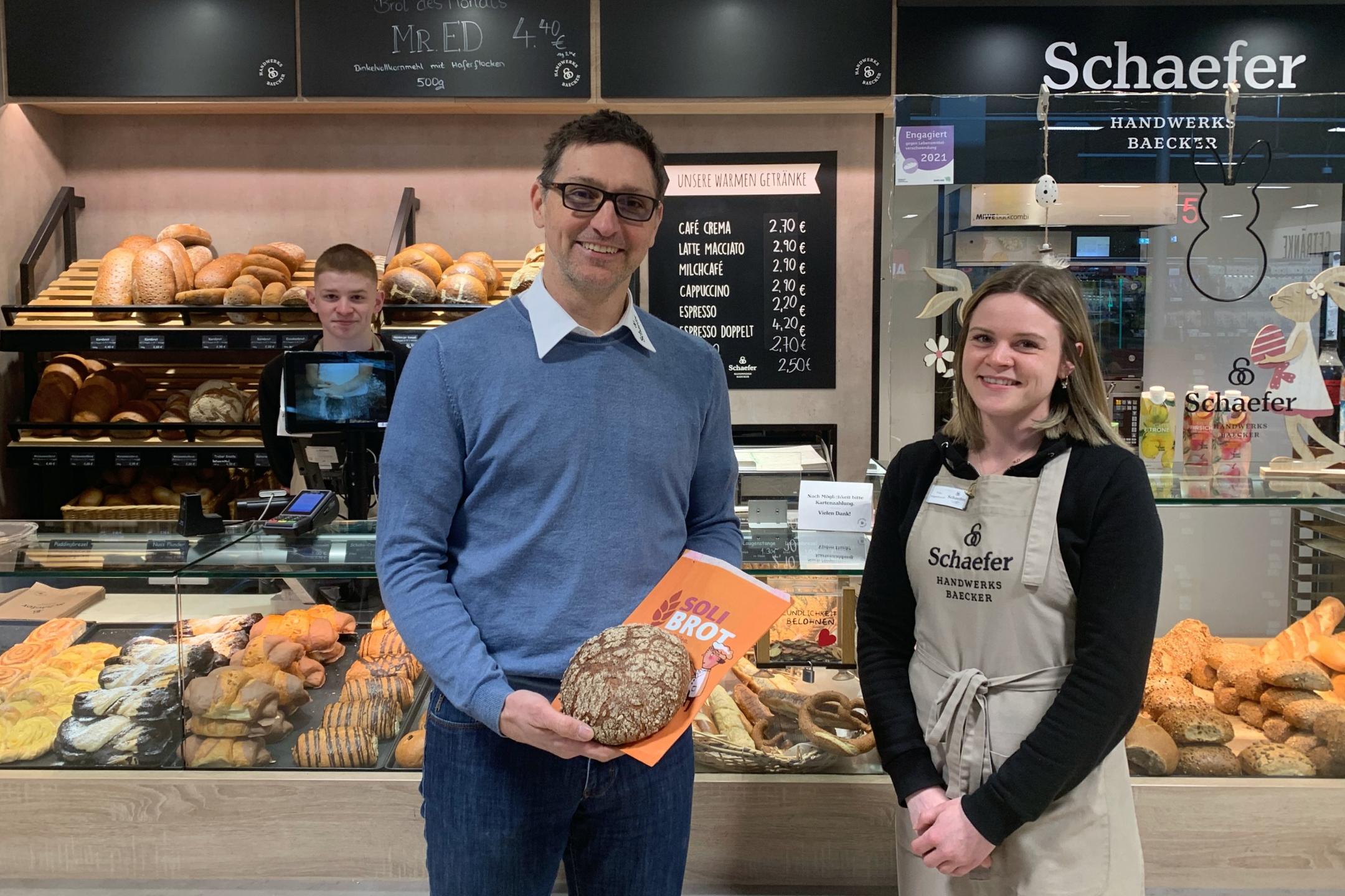 Bäckermeister Sebastian Schaefer präsentiert das Soli-Brot mit seinen Auszubildenden Melanie Wagenknecht und Nico Schiestel.