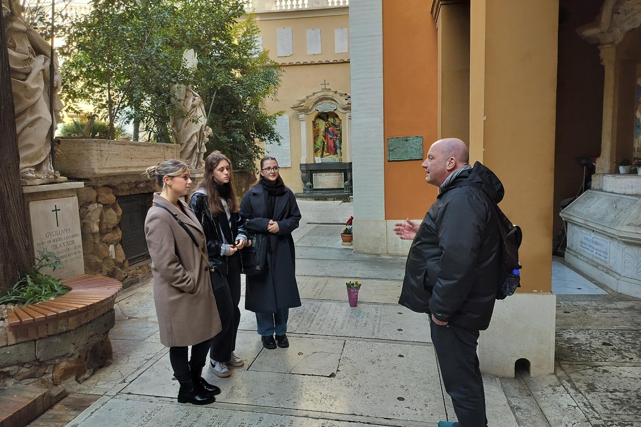 Giulia Tuttolomondo, Lisa Lambert, Louisa König (von links) besichtigen mit Pastoralreferent Markus-Krogull-Kalb den Campo Santo Teutonico im Vatikan.
